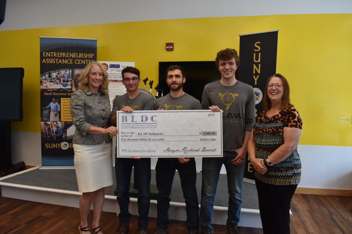 Faculty and three students at the Entrepreneurship Assistance Center hold a large check from the Binghamton Local Development Corporation